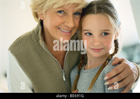 Hauts femme avec bras autour de sa petite-fille, portrait Banque D'Images