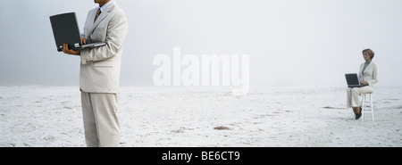 Les professionnels sur la plage l'utilisation d'ordinateurs portatifs Banque D'Images