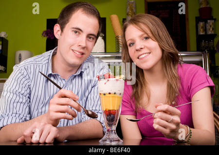 Trendy young couple un kniccurbockerglory (un fruit tropical sundae) dans un endroit frais et café. Banque D'Images