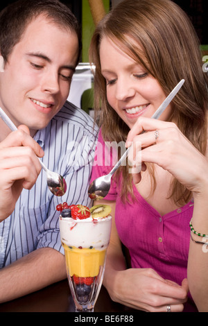 Trendy young couple un kniccurbockerglory (un fruit tropical sundae) dans un endroit frais et café. Banque D'Images