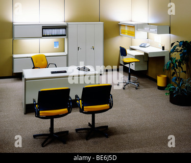 bureau d'affaires 1970s heures sur 24, 7 jours sur 7 avec bureau mural et chaises jaunes Banque D'Images