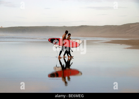 Les surfeurs avec des conseils sur Broad Oak beach Cornwall UK Banque D'Images