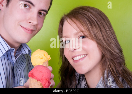 Un jeune homme et femme partageant des cornets de crème glacée. Banque D'Images