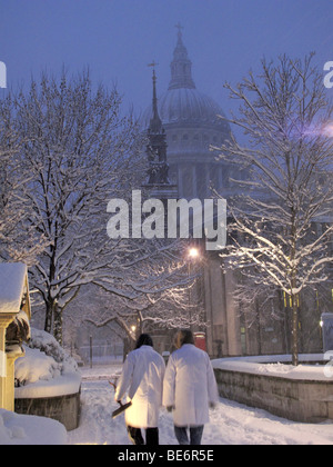 Les gens marchent dans la neige près de la Cathédrale St Paul à Londres Banque D'Images