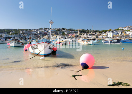 Les bateaux de pêche amarrés dans l'eau claire d'une plage de port. Banque D'Images