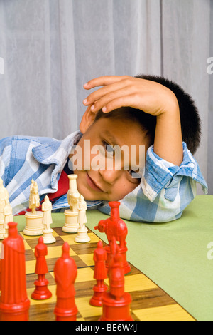 7-8 ans garçon hispanique d'apprendre à jouer aux échecs. M. © Myrleen Pearson Banque D'Images
