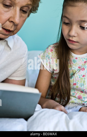 Grand-mère à petite-fille de lecture Banque D'Images