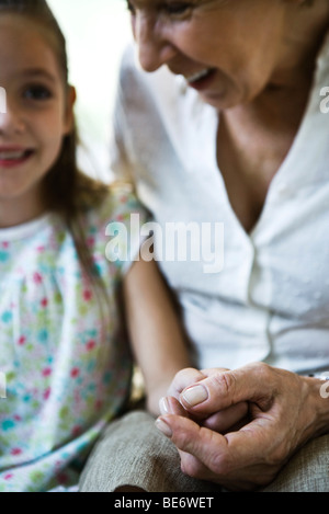 Grand-mère et jeune petite-fille holding hands, close-up Banque D'Images