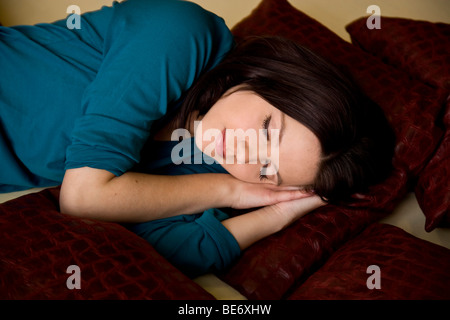 Jeune femme allongée sur son lit, dormir Banque D'Images
