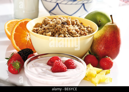 Muesli aux fruits avec du yogourt, framboises, fraises, poire, pomme, oranges, caramboles Banque D'Images