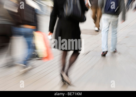 Les piétons circulant sur un trottoir, vue arrière, blurred Banque D'Images