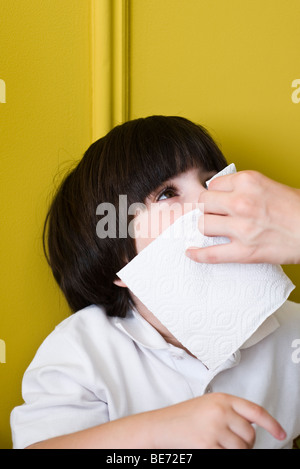 Little Boy blowing nose avec l'aide d'adultes, cropped Banque D'Images