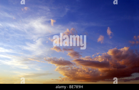 Ciel bleu au coucher du soleil, avec des nuages blancs et orange Banque D'Images