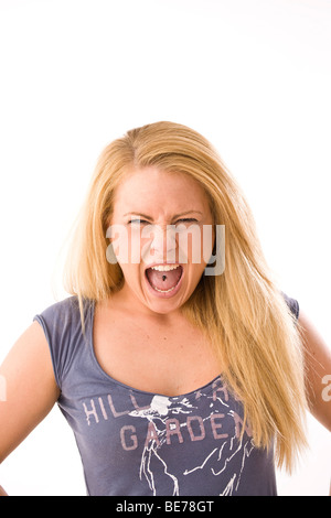 Portrait d'une jeune femme blonde crier, sa langue percé Banque D'Images