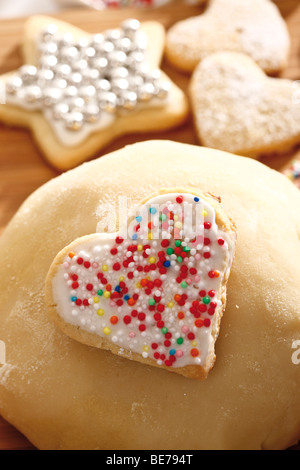 Heart-shaped cookie pâte brisée sucre avec des perles sur une boule de pâte Banque D'Images