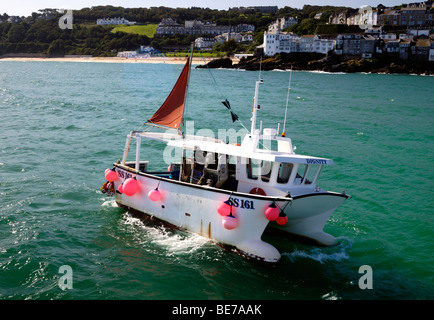 Un petit bateau de pêche dans une houle venant dans le port Banque D'Images