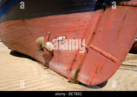 Gros plan du fond d'un vieux bateau échoué sur le sable dans un port à marée basse Banque D'Images