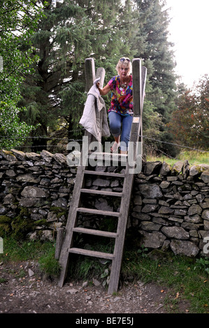 Une femme monte sur une échelle près de Post Knott au-dessus de Bowness dans le Lake District de Cumbria au Royaume-Uni Banque D'Images