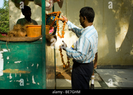 Un homme achète une guirlande d'offrir à un temple à Janakpuri, New Delhi, Inde Banque D'Images