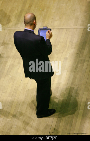 Trader est la marche sur le plancher de la bourse avec une tablette électronique à la main, dans un costume d'affaires Banque D'Images