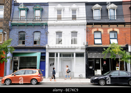 Les piétons circulant en façade des immeubles d'habitation le long de l'élégant quartier de West Queen West du centre-ville de Toronto, Ontario, Canada. Banque D'Images
