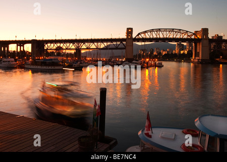 Vue sur False Creek et Burrard Bridge, de Ganville Island, Vancouver, Canada. Un traversier de Granville Island arrive dans un flou. Banque D'Images