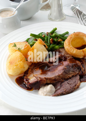 Une assiette de tranches de rôti de bœuf désossée de boeuf et légumes dans une table Banque D'Images