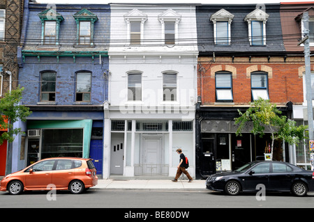 Une boutique de marche des piétons par des immeubles d'habitation le long de l'élégant quartier de West Queen West du centre-ville de Toronto, Ontario, Canada. Banque D'Images