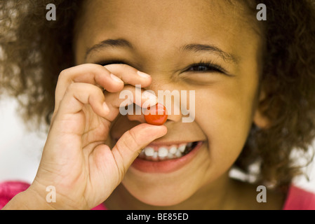 Little girl holding up bonbon Banque D'Images