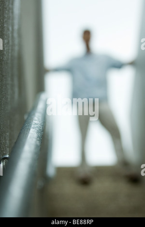 Homme debout en haut de l'escalier, blurred Banque D'Images