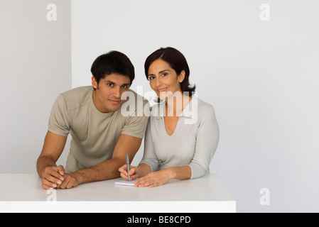 Mère et fils adulte avec le bloc-notes, portrait Banque D'Images