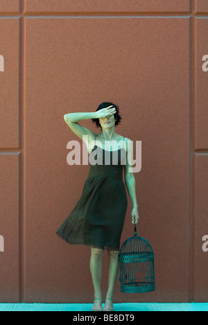 Woman holding empty birdcage, dos de la main qui a eu lieu au front Banque D'Images