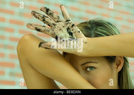 Femme avec des mains sales élever les bras en avant face Banque D'Images