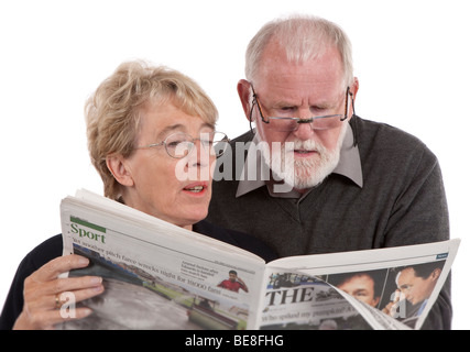 Couple de retraités plus âgés journal lecture ensemble Banque D'Images