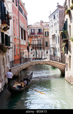 Gondoliers amènent les touristes à Venise, sur une promenade en bateau à travers les canaux merveilleux de la ville.L'Italie Banque D'Images