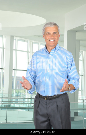 Businessman wearing Striped shirt Bleu faisant des gestes avec les deux mains dans la configuration de bureau Banque D'Images