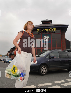 Femme d'âge moyen supermarché Morrisons laissant shopper Shropshire Wellington England Uk Banque D'Images