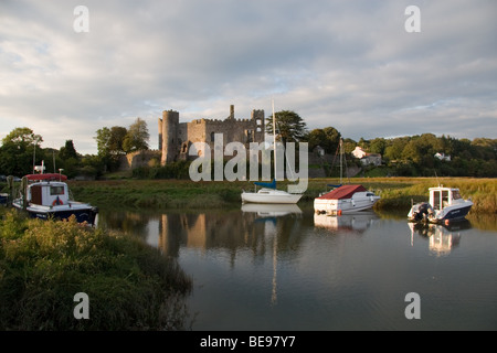 Laugharne castle en début de soirée avec des bateaux amarrés dans l'avant-plan : Sud du Pays de Galles, Royaume-Uni Banque D'Images