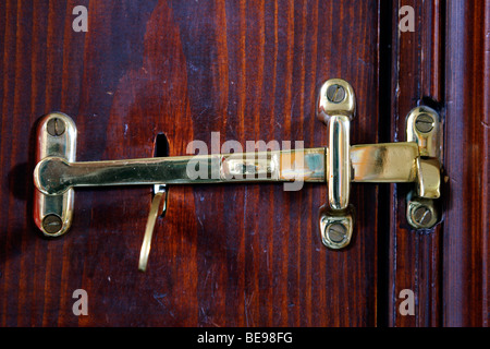 Le laiton loquet situé sur la porte de bois close up Banque D'Images