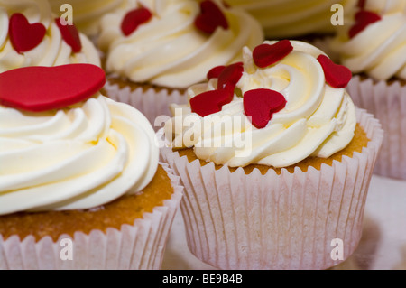 Gâteaux de tasse garnie de crème et rouge coeurs amour Banque D'Images