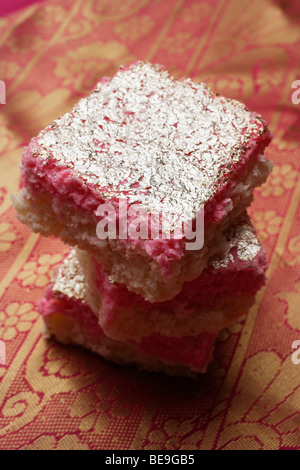 Une pile de bonbons rose indien avec garniture en argent. Banque D'Images