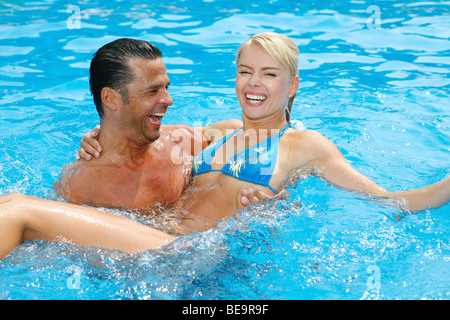 Jeune couple s'amusant dans la piscine. Banque D'Images