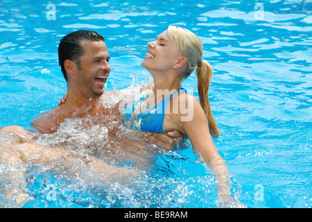 Jeune couple s'amusant dans la piscine. Banque D'Images