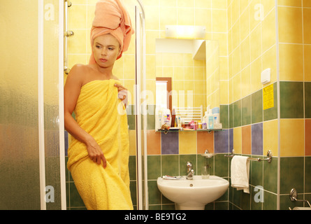 Jeune femme dans la salle de bains enroulée dans une serviette, après la douche. Banque D'Images
