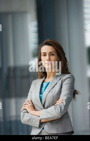 Confident Hispanic businesswoman with arms crossed Banque D'Images