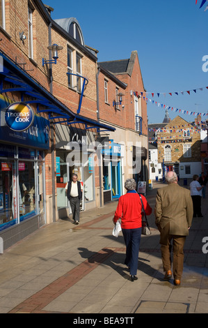 Les gens marcher dans une zone piétonne à Market Harborough, Leicestershire Banque D'Images