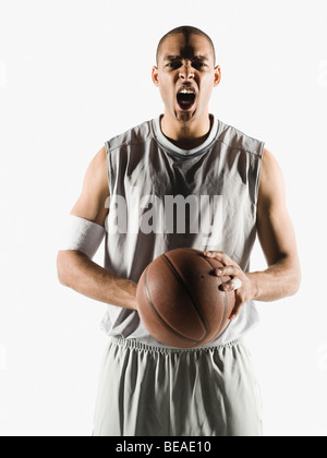 Angry African man holding basketball Banque D'Images