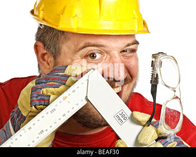 Young caucasian handyman vérifier misure sur son instrument Banque D'Images