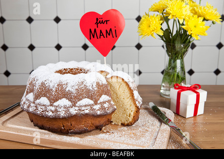 Un gâteau bundt, fleurs et une boîte-cadeau pour la Fête des Mères en Allemagne Banque D'Images