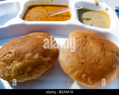 Indiens les éléments sur une plaque en plastique blanc. Ce sont les kachoris avec une pomme de terre grasse curry, parfait comme un en-cas rapide. Banque D'Images